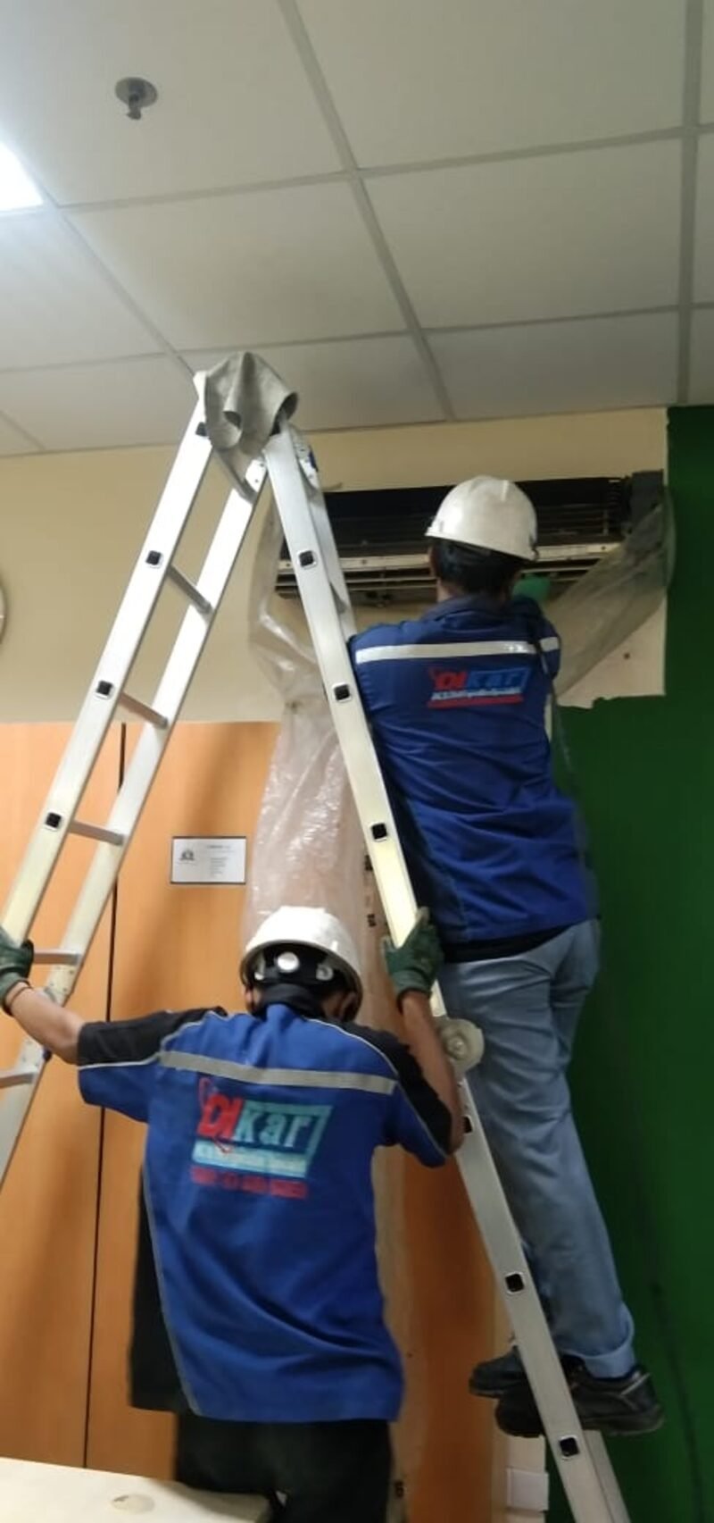 Dua teknisi PT Dikari merawat AC Split Duct